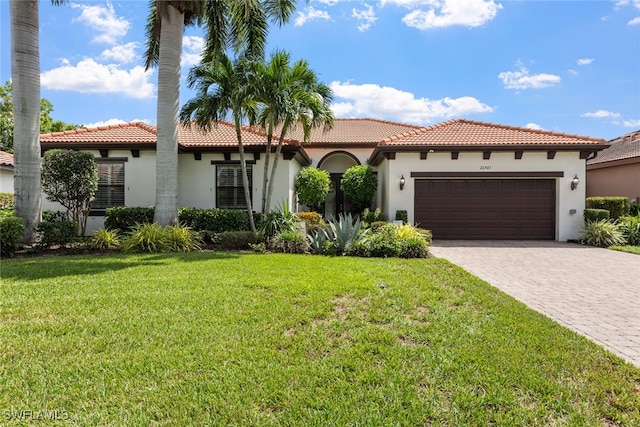 mediterranean / spanish house featuring a front yard and a garage