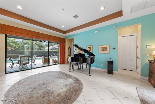 sitting room with plenty of natural light, a raised ceiling, and light tile patterned flooring