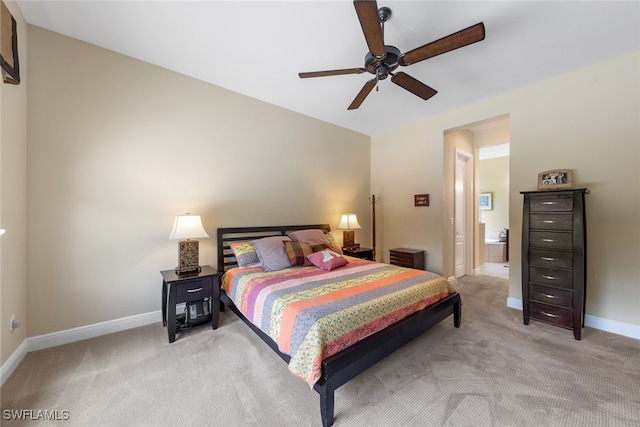 bedroom featuring ceiling fan, light colored carpet, and ensuite bathroom