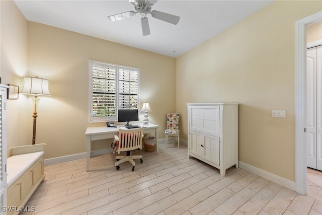 office with light wood-type flooring and ceiling fan