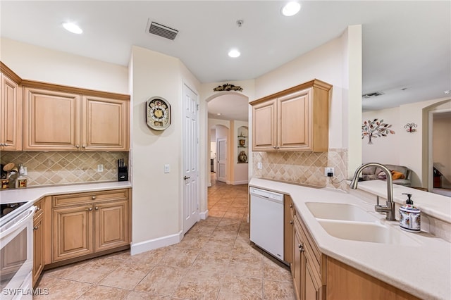 kitchen with dishwasher, light tile patterned flooring, sink, and decorative backsplash