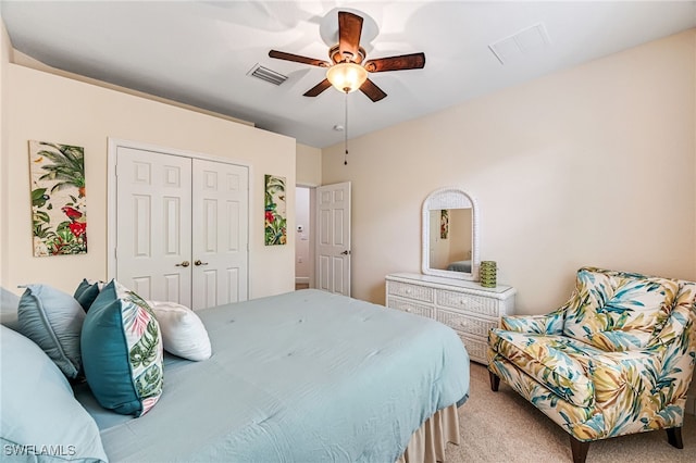 bedroom with a closet, ceiling fan, and light carpet