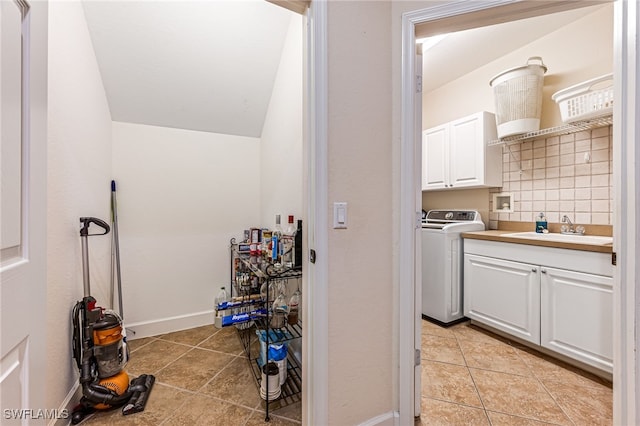 washroom featuring washer / clothes dryer, cabinets, sink, and light tile patterned flooring