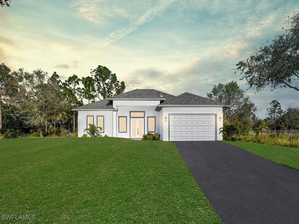 prairie-style home with a garage and a yard