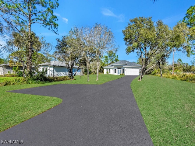 ranch-style home featuring a garage and a front lawn