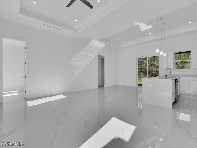 spare room featuring ceiling fan, crown molding, sink, and a tray ceiling