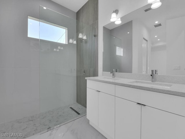 bathroom with vanity and tiled shower