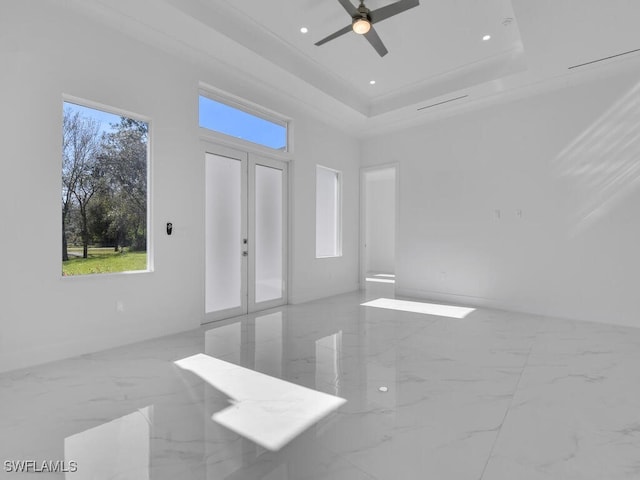 spare room with french doors, a tray ceiling, ceiling fan, and ornamental molding
