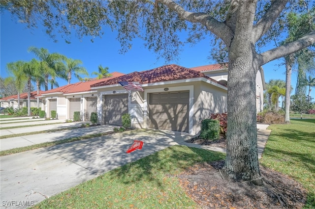 mediterranean / spanish-style home with a garage and a front lawn