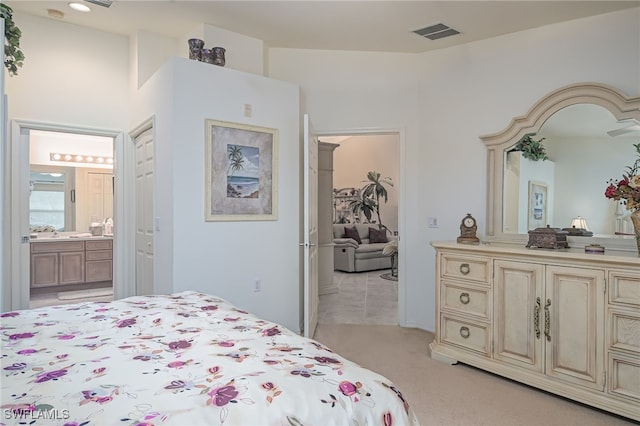 carpeted bedroom featuring vaulted ceiling, sink, and ensuite bath