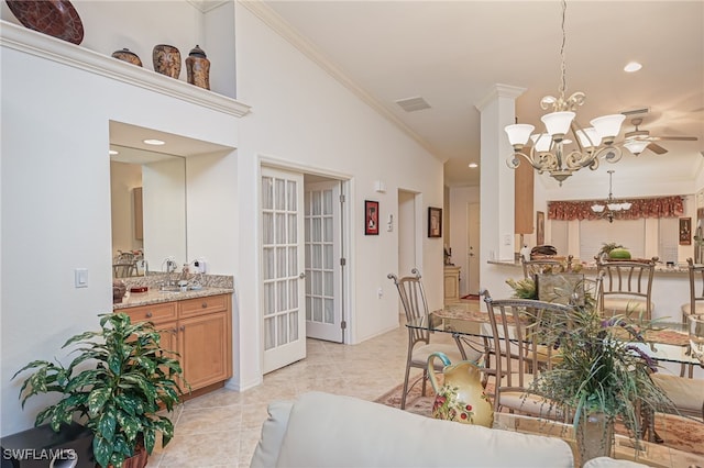 dining area featuring sink, ornamental molding, ceiling fan with notable chandelier, and light tile patterned flooring