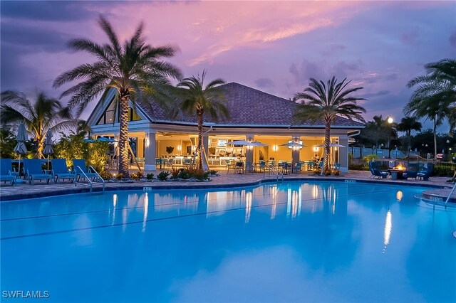 pool at dusk featuring a patio area