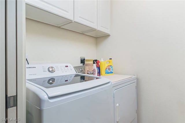 washroom with cabinets and washing machine and dryer