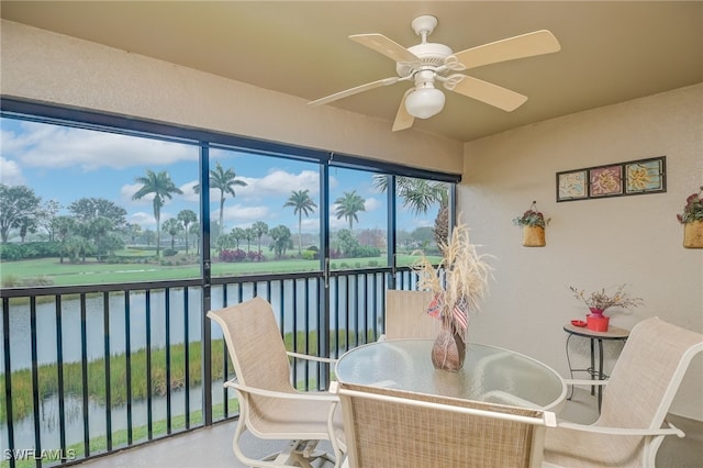 sunroom with a water view, ceiling fan, and a healthy amount of sunlight