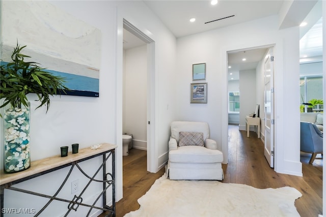 sitting room with baseboards, wood finished floors, a wealth of natural light, and recessed lighting