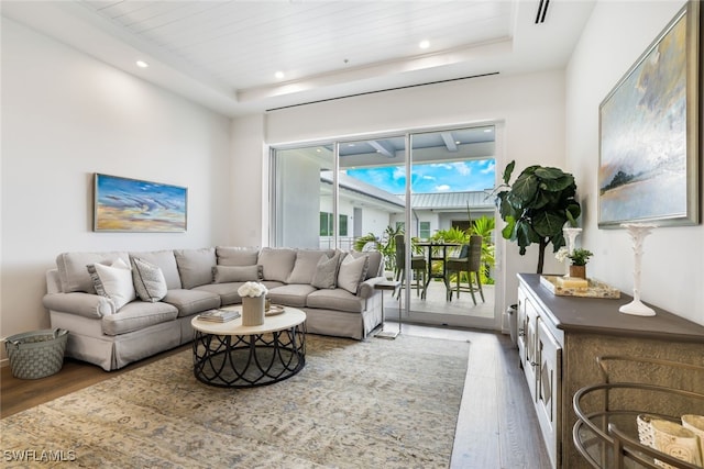 living room featuring a raised ceiling, wood finished floors, wood ceiling, and recessed lighting