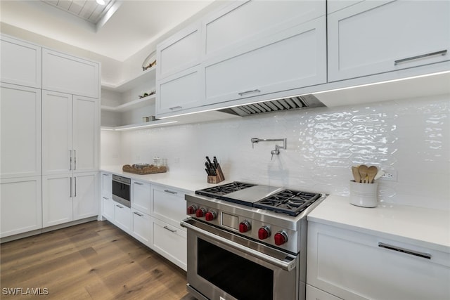 kitchen with light countertops, luxury stove, white cabinets, and decorative backsplash