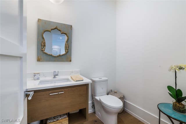 bathroom with vanity, toilet, and wood-type flooring