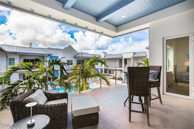 view of patio with a balcony and an outdoor pool