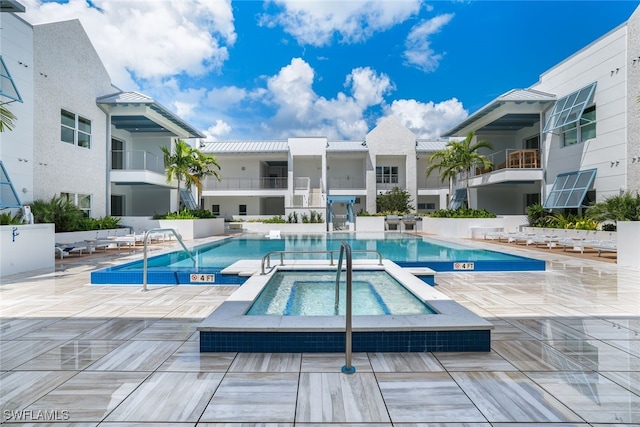 pool with a community hot tub and a patio