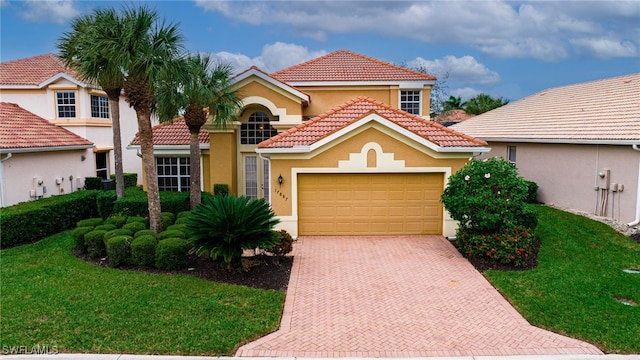 mediterranean / spanish house featuring a front lawn and a garage