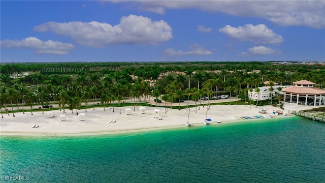 birds eye view of property with a water view and a beach view