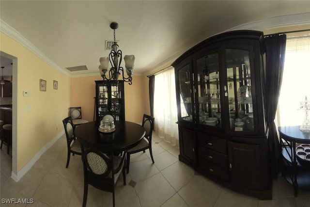 dining space featuring an inviting chandelier, crown molding, and tile patterned floors