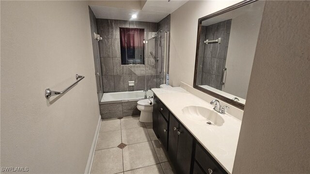 full bathroom featuring tiled shower / bath, vanity, toilet, and tile patterned floors