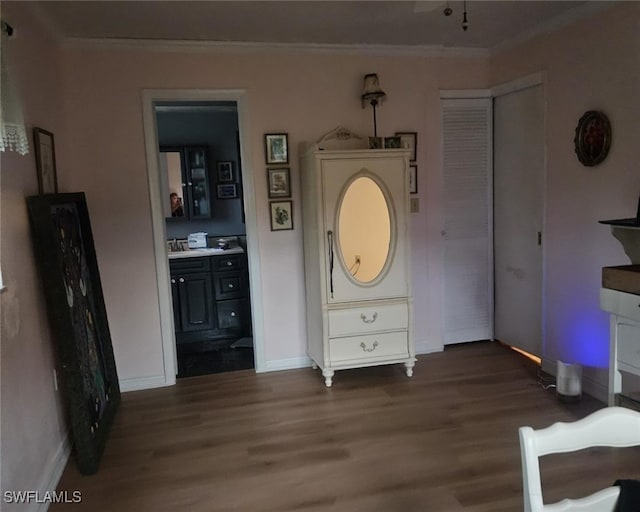 interior space with dark wood-type flooring, ensuite bathroom, and crown molding