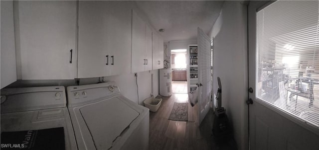 washroom with cabinet space, wood finished floors, washer and dryer, and electric water heater