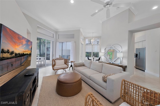 living room featuring light tile patterned floors, crown molding, a high ceiling, and ceiling fan with notable chandelier