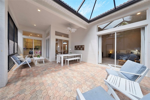 sunroom / solarium with ceiling fan and vaulted ceiling with beams