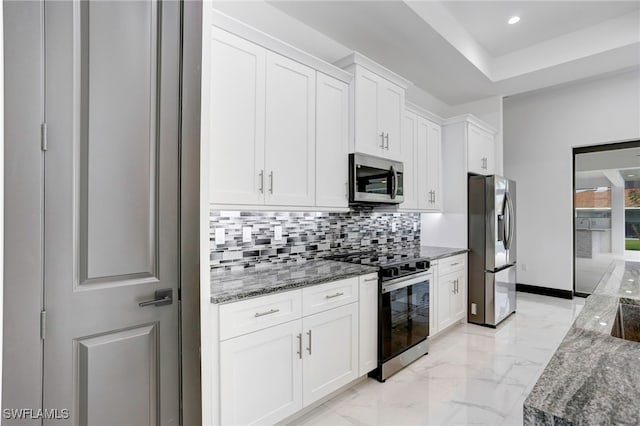 kitchen featuring marble finish floor, appliances with stainless steel finishes, backsplash, and white cabinets