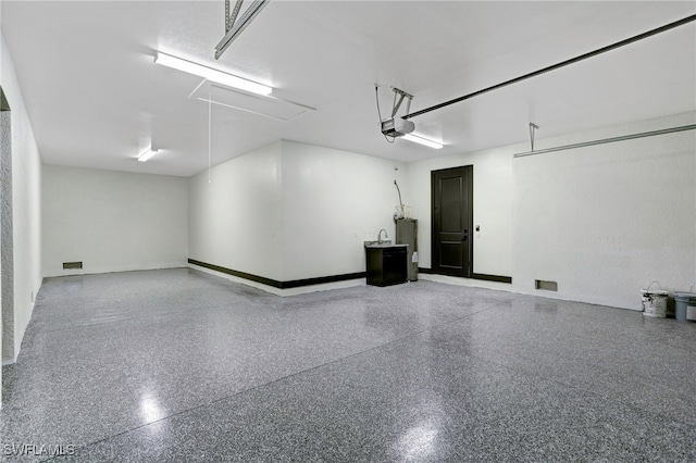 garage featuring a garage door opener and electric water heater