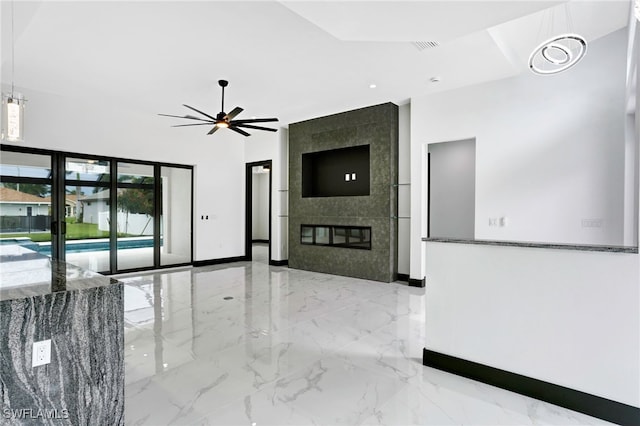 interior space with a large fireplace, visible vents, baseboards, ceiling fan, and marble finish floor