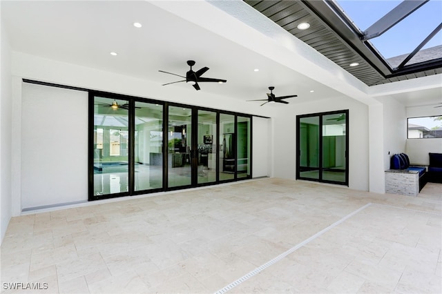 view of patio with glass enclosure and a ceiling fan