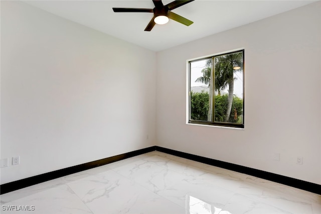 empty room with marble finish floor, ceiling fan, and baseboards