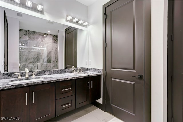 bathroom with marble finish floor, double vanity, a sink, and a marble finish shower