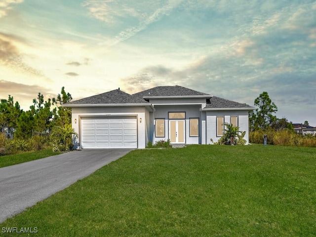 prairie-style house with a yard and a garage