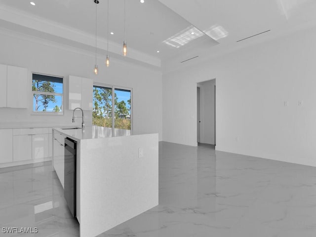 kitchen featuring sink, hanging light fixtures, stainless steel dishwasher, an island with sink, and white cabinets