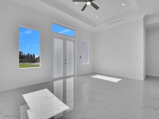 unfurnished room with french doors, a tray ceiling, and ceiling fan