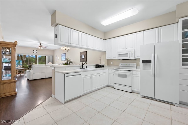 kitchen featuring white cabinets, light wood-type flooring, ceiling fan with notable chandelier, white appliances, and kitchen peninsula