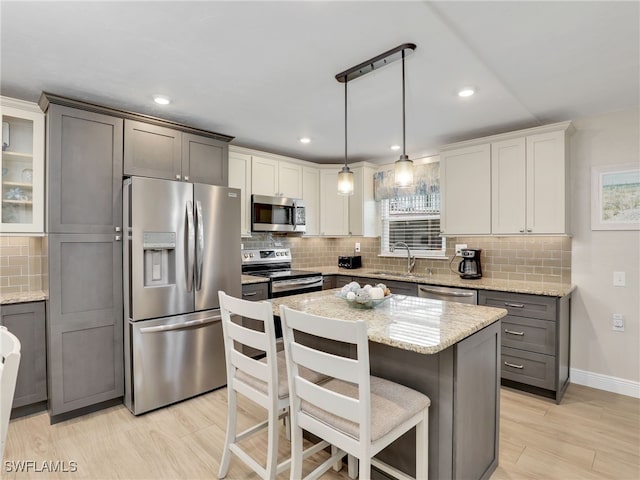 kitchen with appliances with stainless steel finishes, hanging light fixtures, sink, and a wealth of natural light