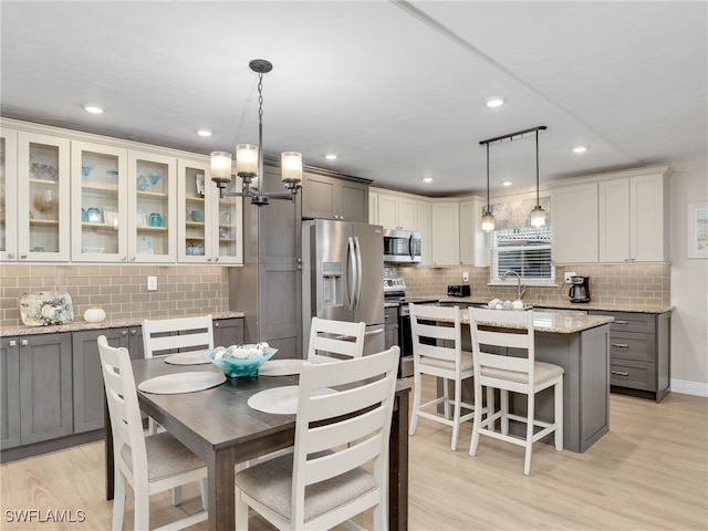 dining room with a notable chandelier, light hardwood / wood-style flooring, and sink