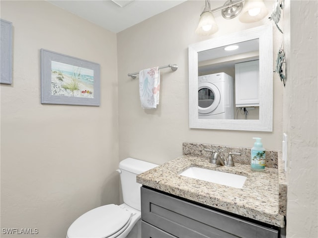 bathroom with stacked washer and clothes dryer, vanity, and toilet