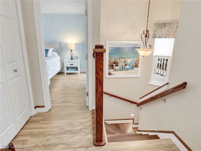 staircase with a chandelier and hardwood / wood-style floors