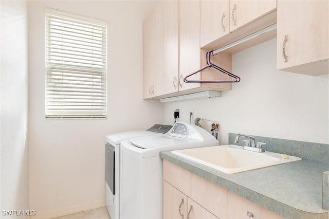 washroom with sink, washing machine and dryer, and cabinets