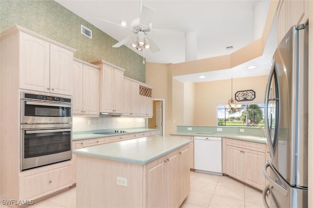 kitchen with light tile patterned floors, a kitchen island, visible vents, light countertops, and appliances with stainless steel finishes