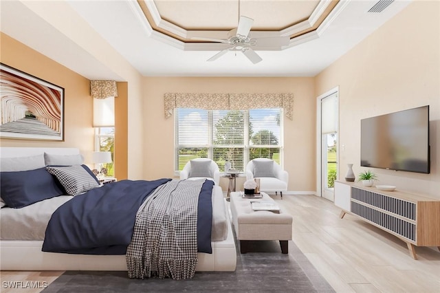 bedroom featuring ceiling fan, ornamental molding, a raised ceiling, and visible vents