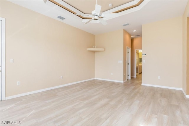 unfurnished room featuring baseboards, a ceiling fan, visible vents, and light wood-style floors